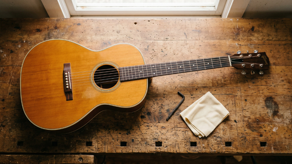 A guitar on a luthiers table ready to be set up to reduce pain and tension in playing 